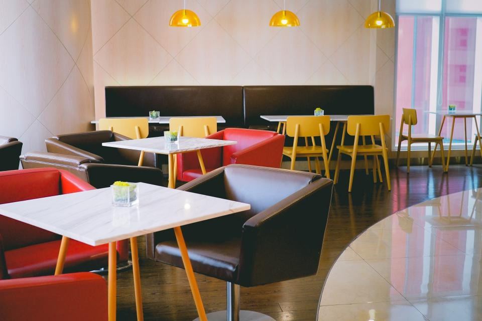 Bright café interior with colourful chairs and pendant lights