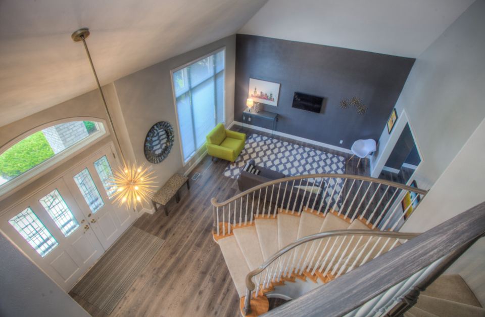 Open apartment interior with a staircase and living area seen from above