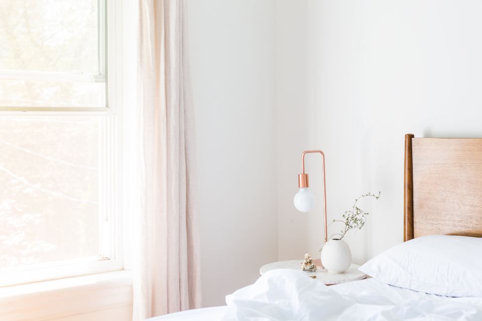 Calm bedroom with soft white bedding and natural light