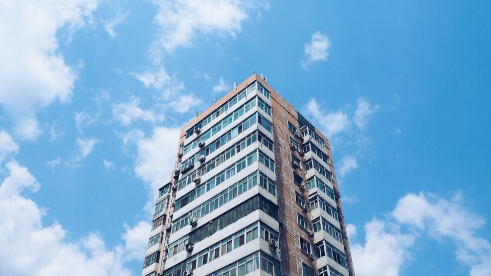 High-rise residential apartment tower against a blue sky