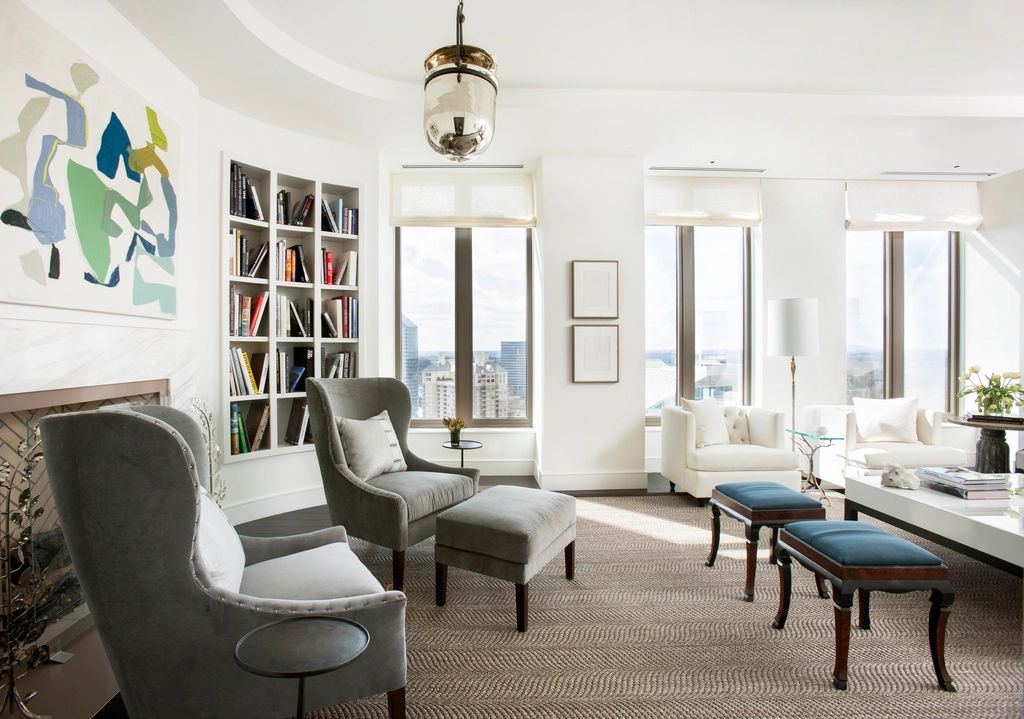 Elegant apartment lounge with grey armchairs and tall windows