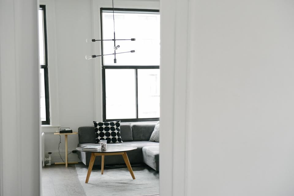 Minimal apartment corner with a sofa, round coffee table and plants