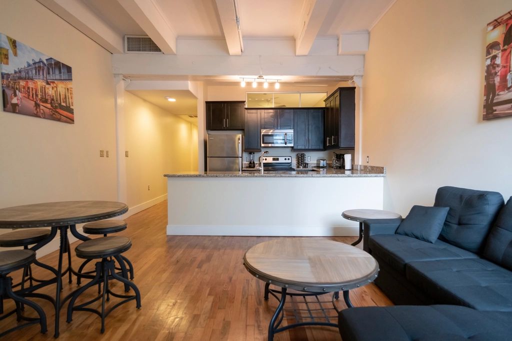 Open apartment kitchen with a breakfast bar, stools and pendant lights