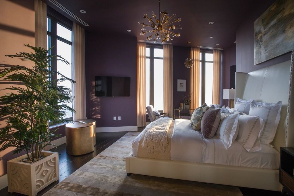 Elegant modern bedroom with a chandelier, plush bed and large windows