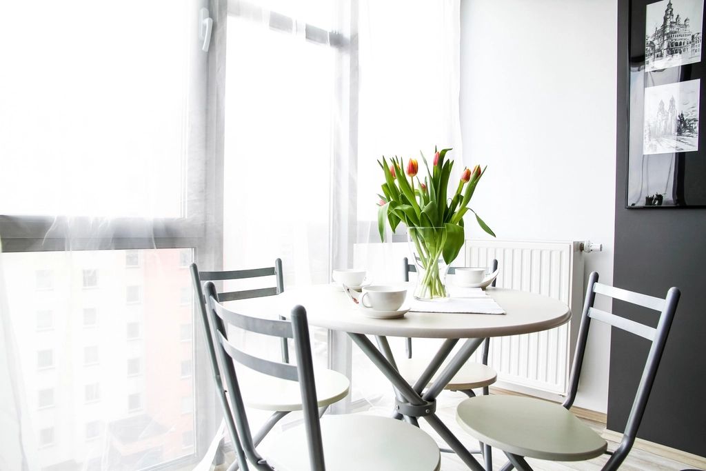 Small round dining table with chairs by a bright window