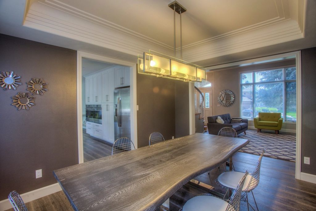 Long wooden dining table in an open-plan space with pendant lights