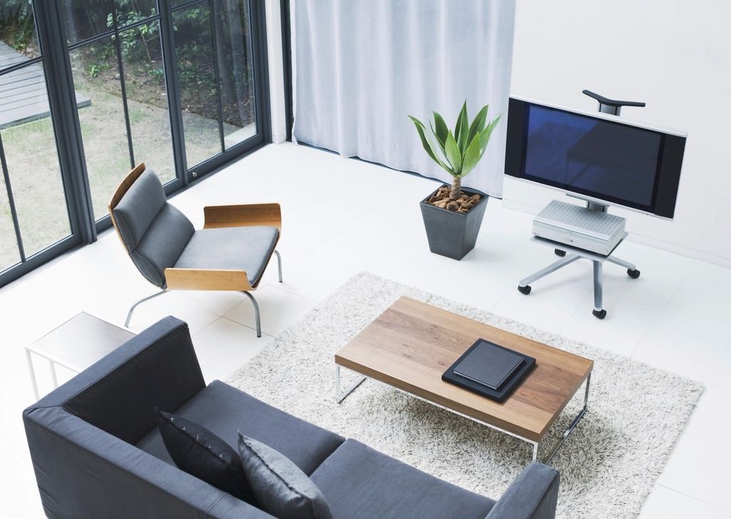 Minimal modern living room with grey sofa, wooden coffee table and large windows