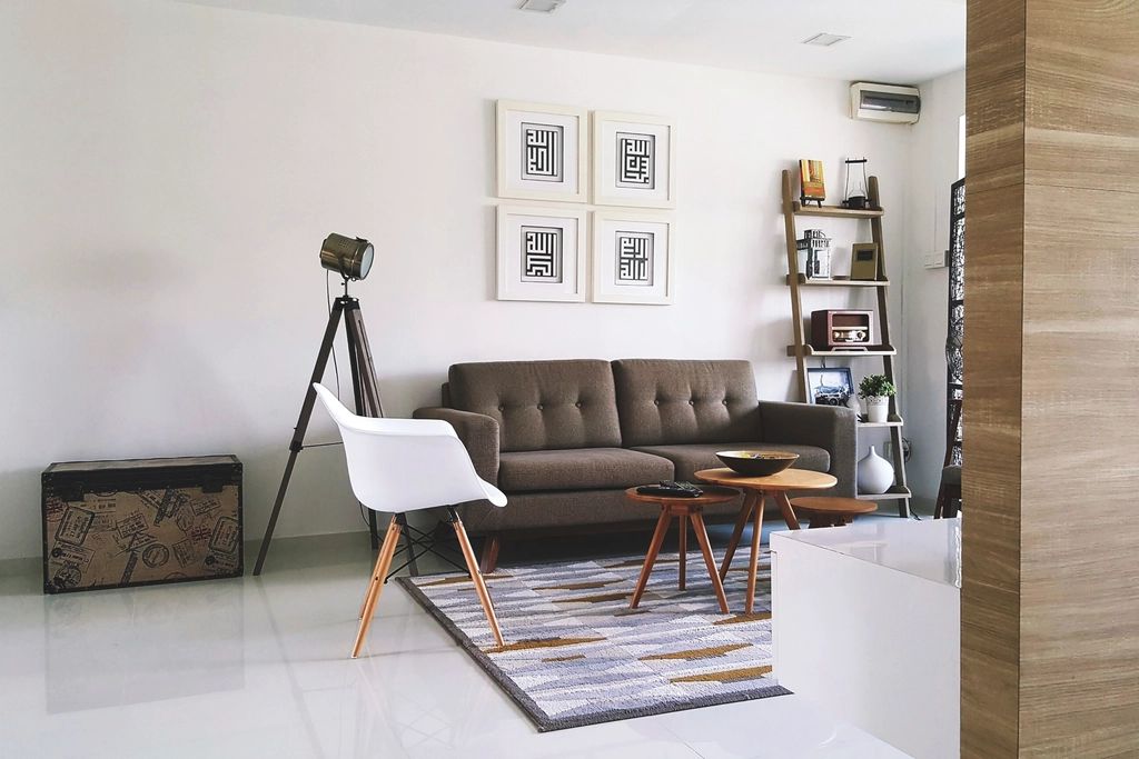 Living room with a brown leather sofa, framed art and a wooden floor