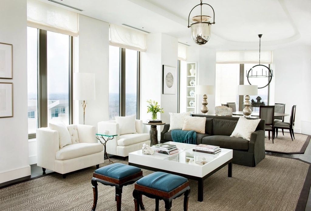 Bright modern living room with white sofas, a coffee table and pendant lights