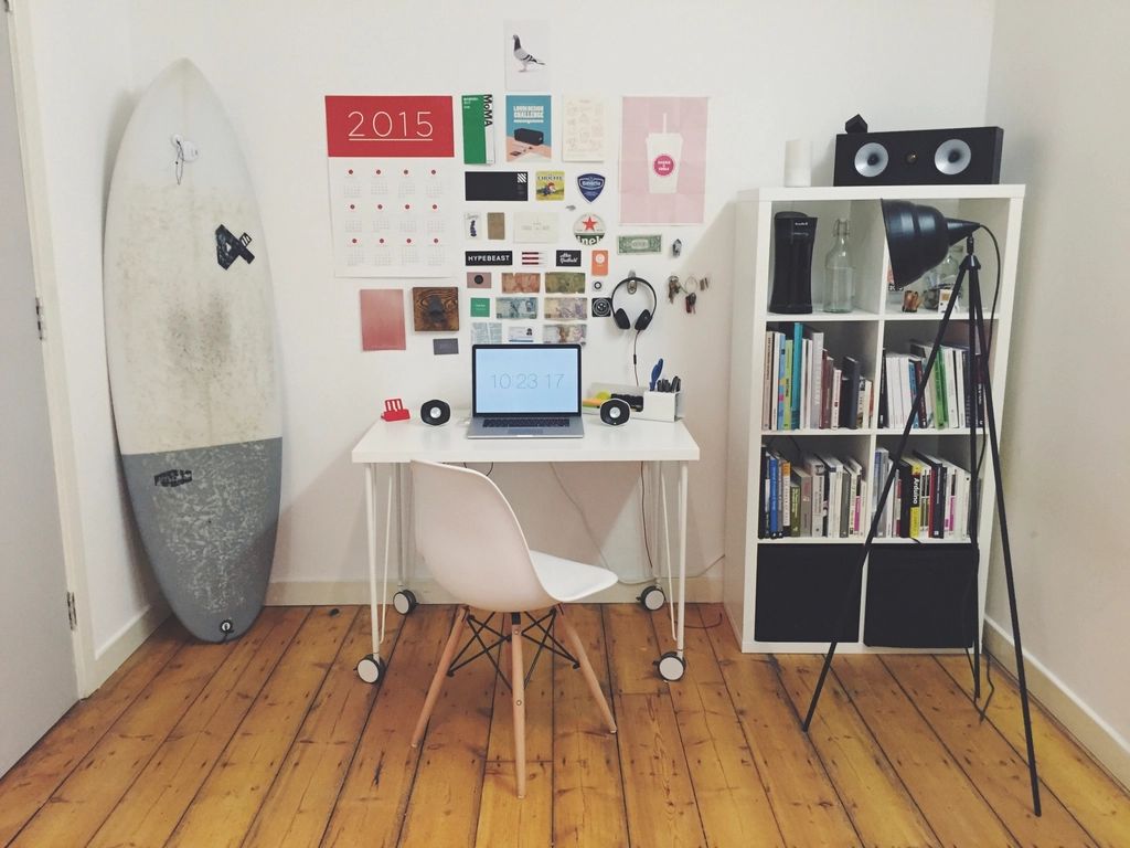 Small room with a white desk, shelves and a light wooden floor