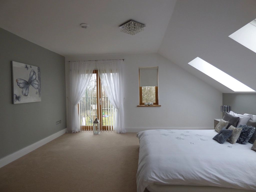 Compact attic bedroom with skylights and light grey walls