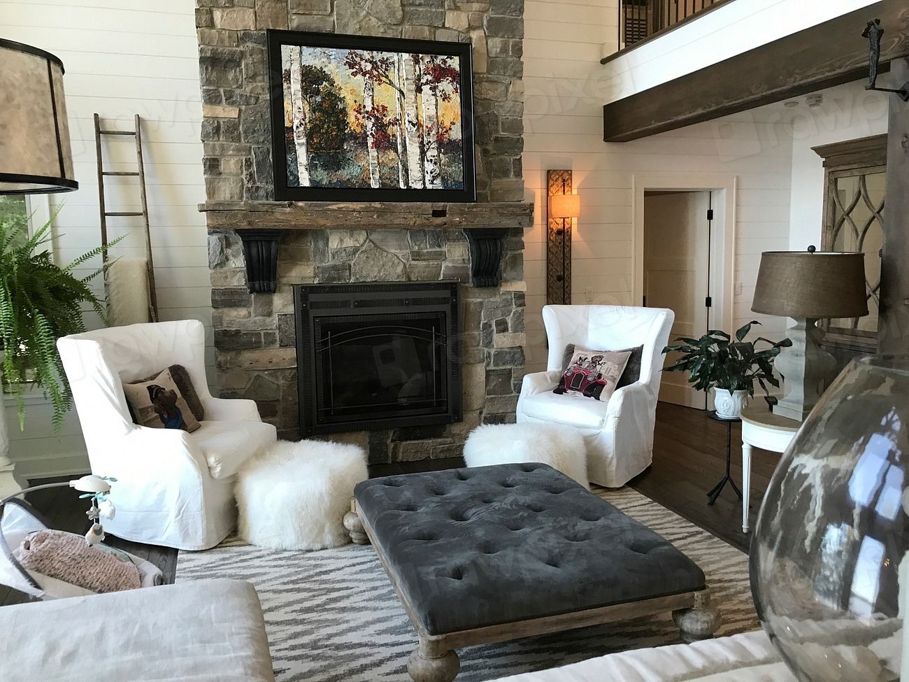 Luxurious living room with a stone fireplace wall and plush seating