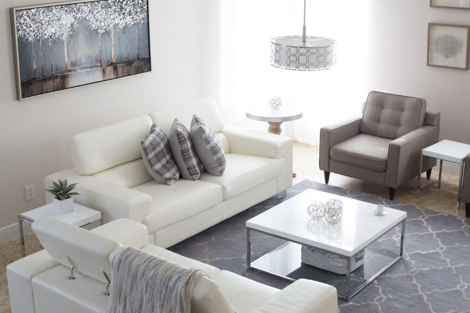Elegant white living room with soft grey accents and natural light