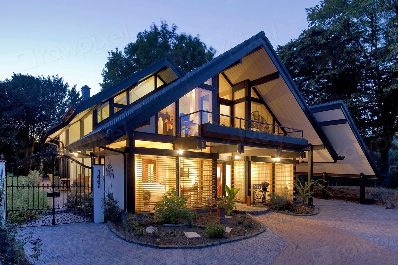 Contemporary villa with large glass windows lit up at dusk